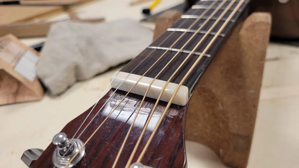 On peut voir un sillet de tête poli, installé sur la guitare pour laquelle il a été fabriqué.